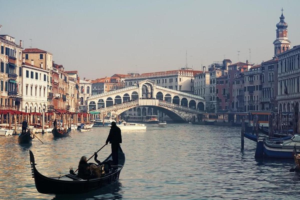 seorang pria di gondola di sungai dengan jembatan
