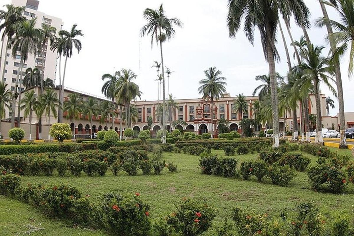 Un gran edificio con palmeras y jardín.
