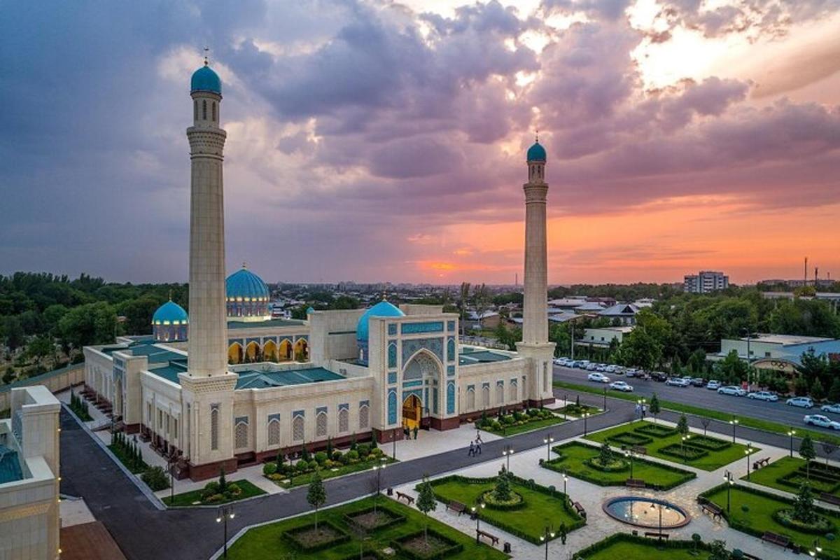 a mosque with two towers in a city at sunset