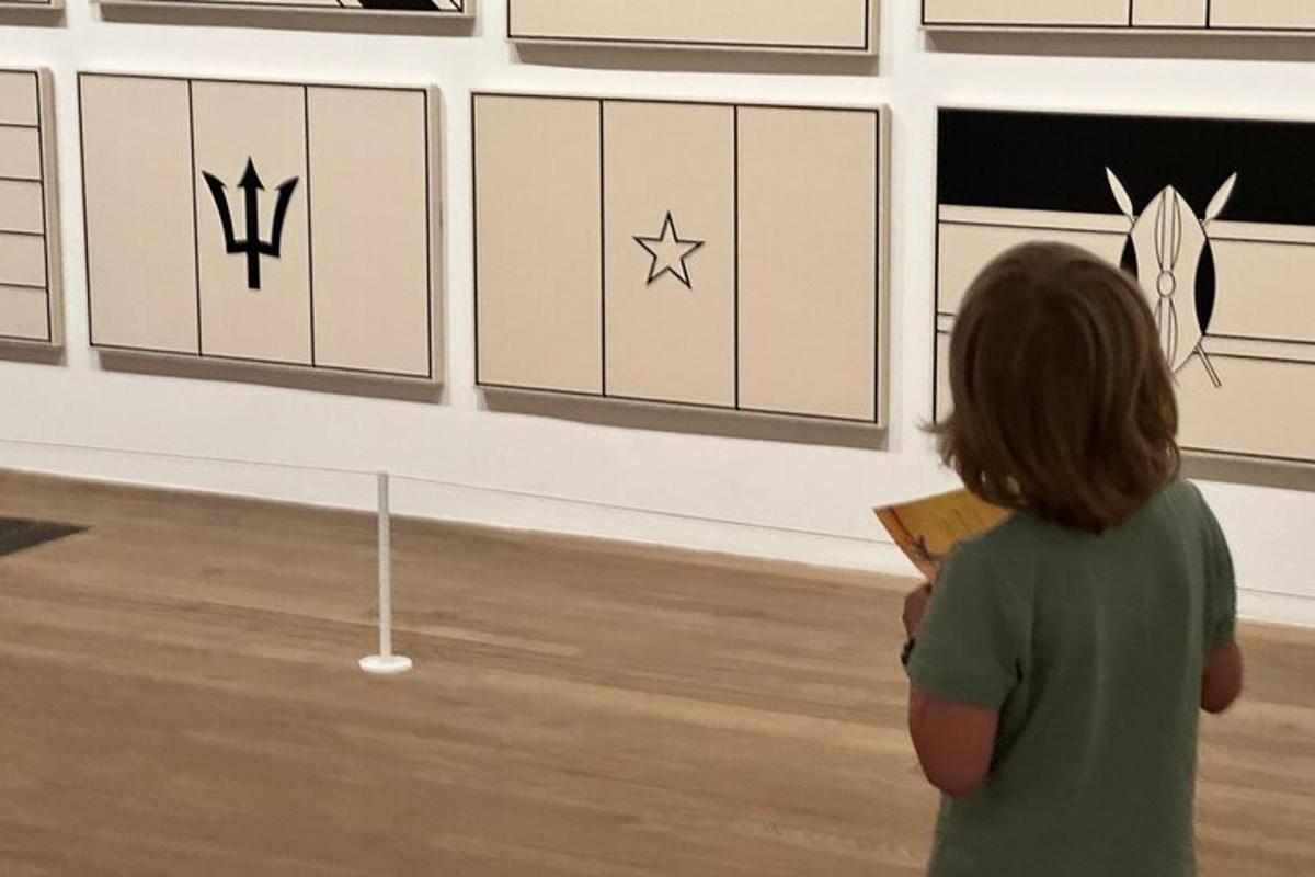 seorang gadis kecil berdiri di hadapan pameran seni