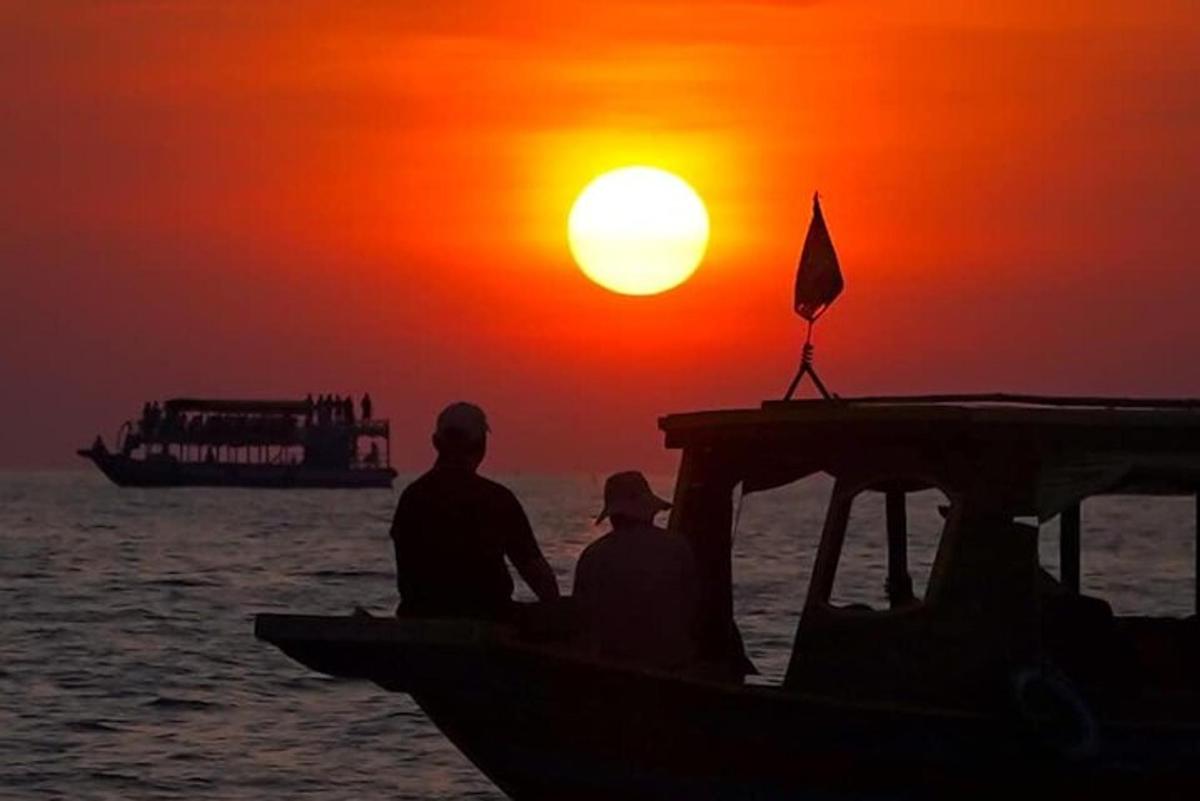 due persone sedute su una barca al tramonto
