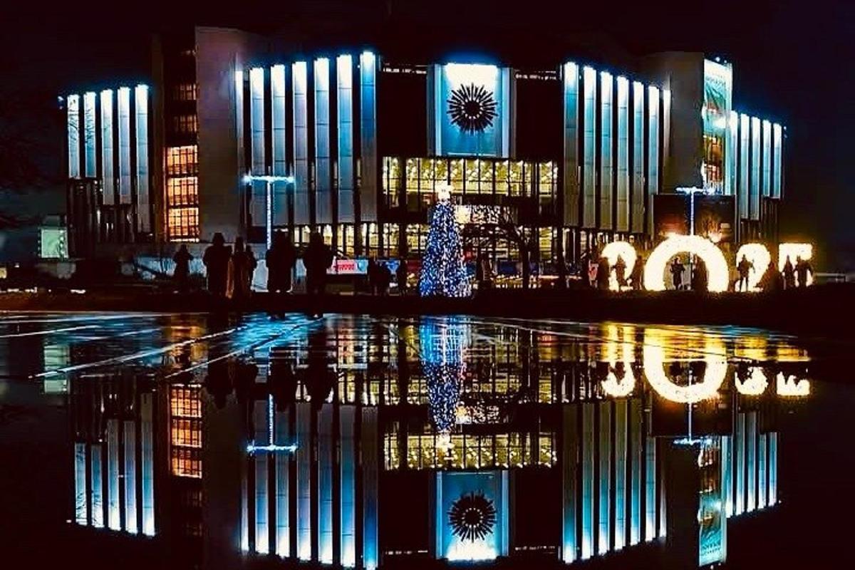 ένα φωτισμένο κτίριο με ένα χριστουγεννιάτικο δέντρο μπροστά του