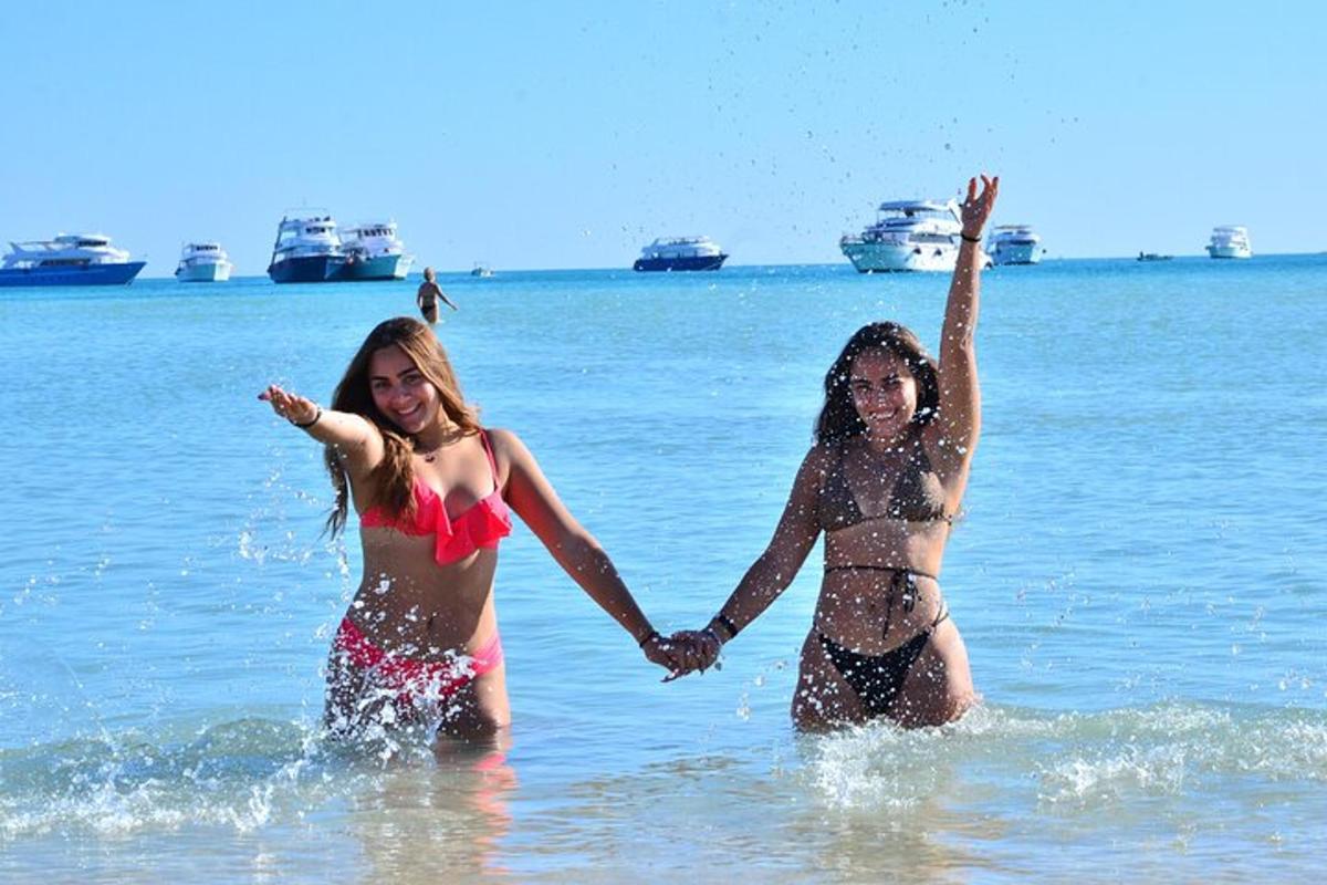 Dve deklici se igrata v vodi na plaži