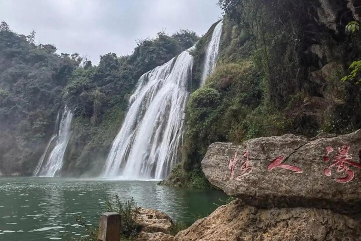 a waterfall in front of a body of water