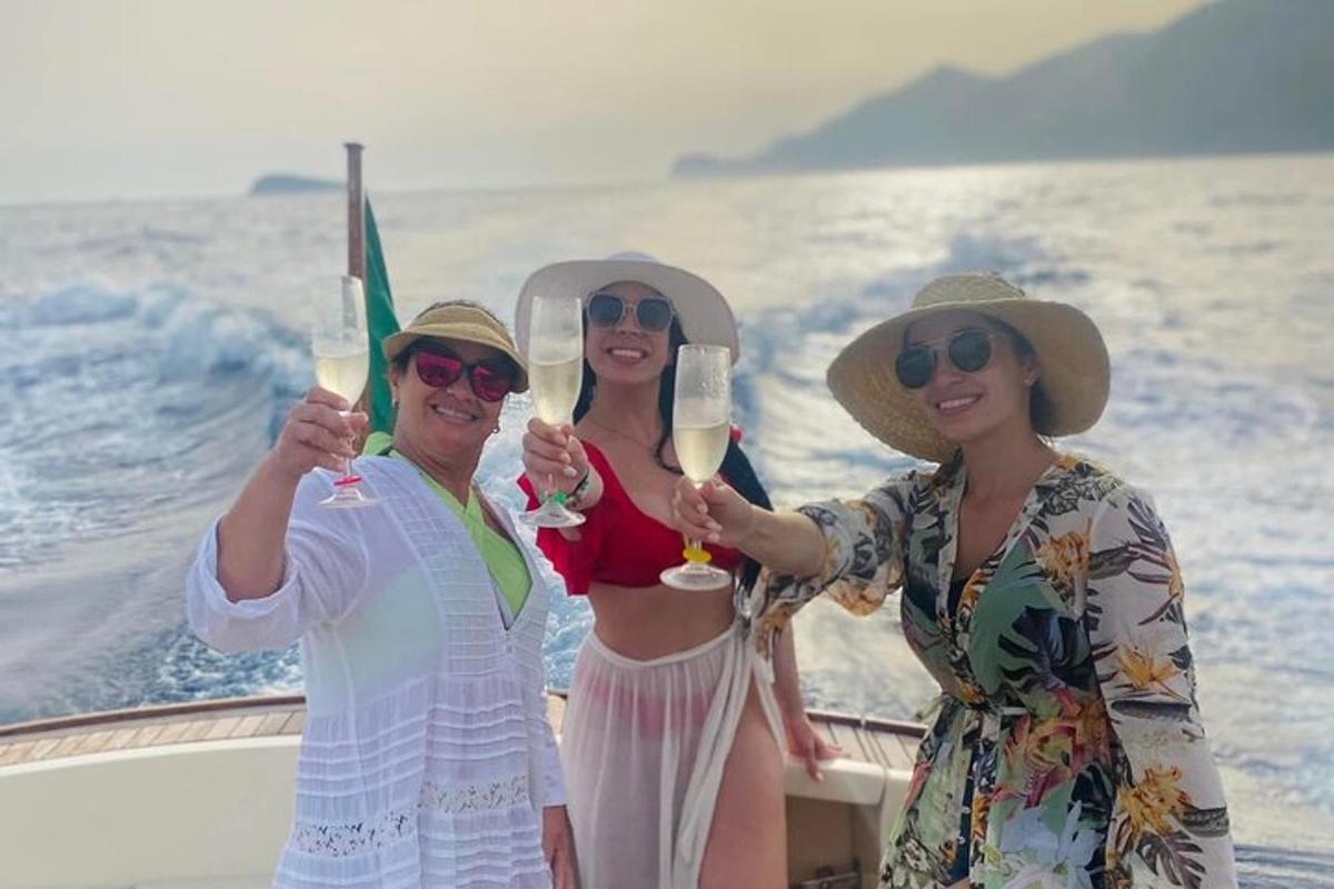 Tres personas en un barco sosteniendo copas de vino