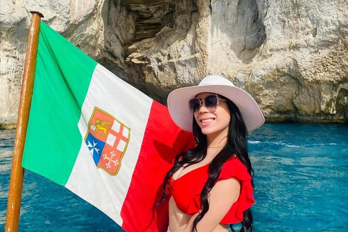 Una mujer con sombrero parada junto a una bandera