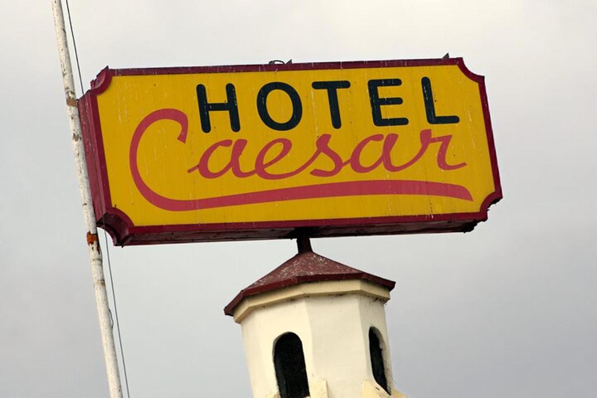un cartello di un hotel con una casseruola in cima a una torre
