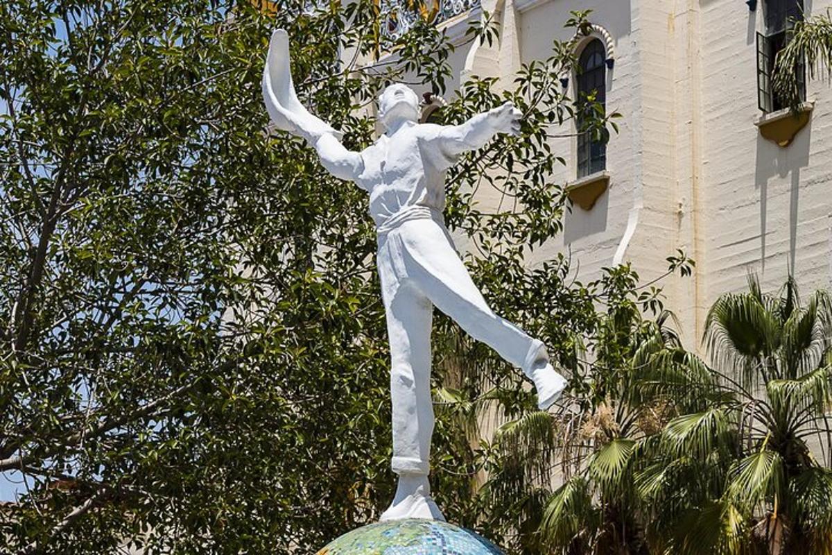 una statua di un uomo che balla davanti a un edificio