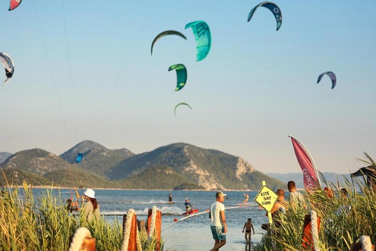 sekumpulan manusia di pantai menerbangkan layang-layang