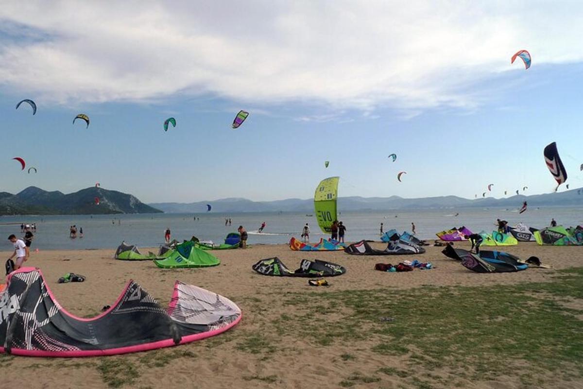 sekumpulan manusia di pantai menerbangkan layang-layang