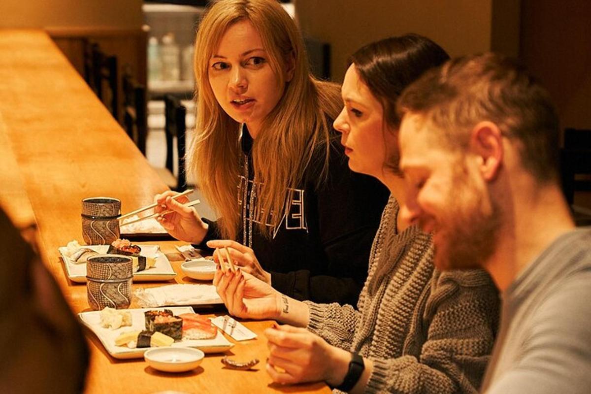 hópur fólks situr við borð og borðar mat