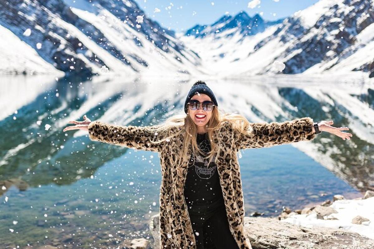 a woman standing in front of a lake with her arms outstretched