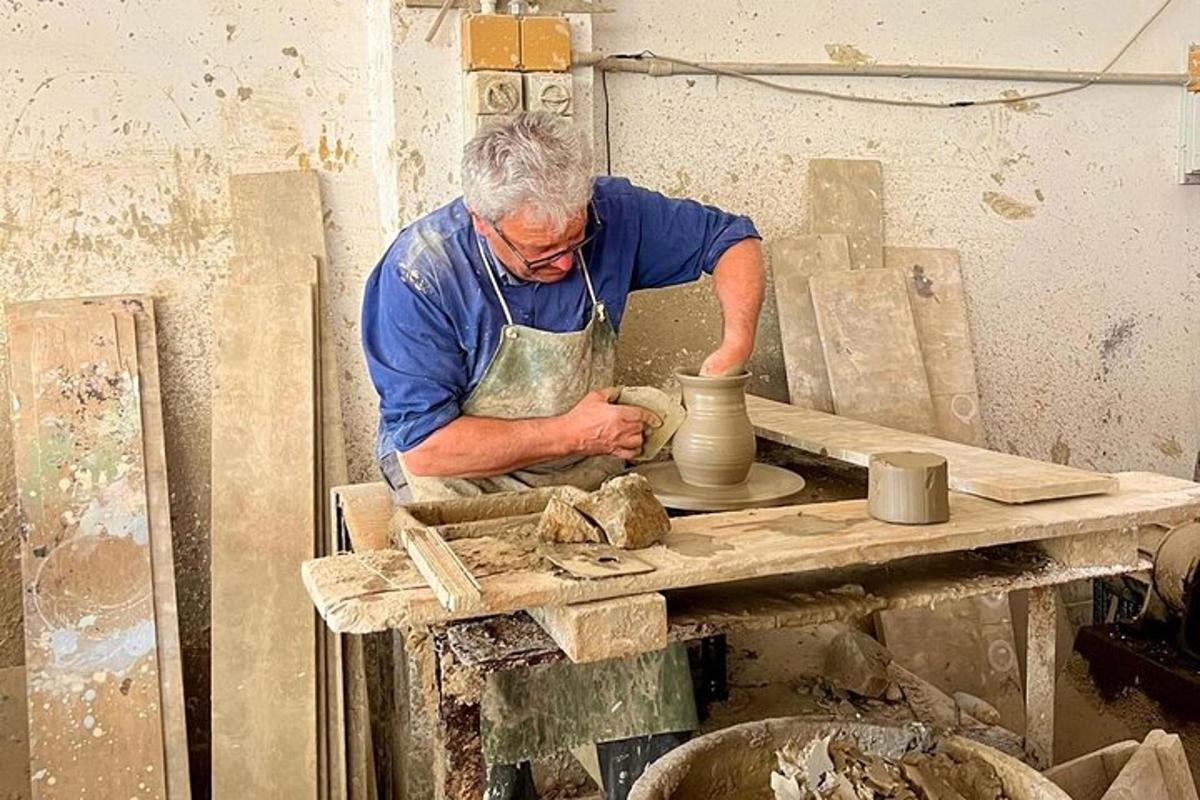 a man making a vase on a pottery wheel