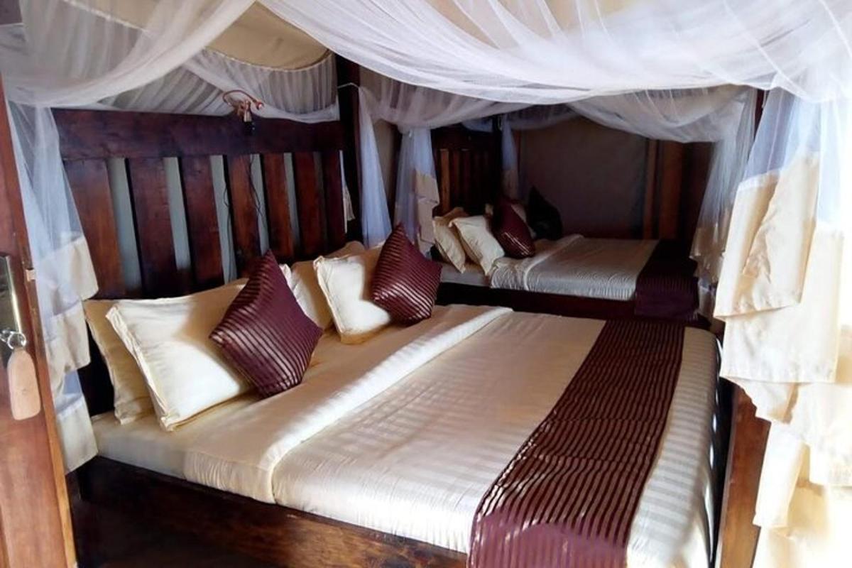 dua katil dalam bilik tidur dengan langsir dan bantal