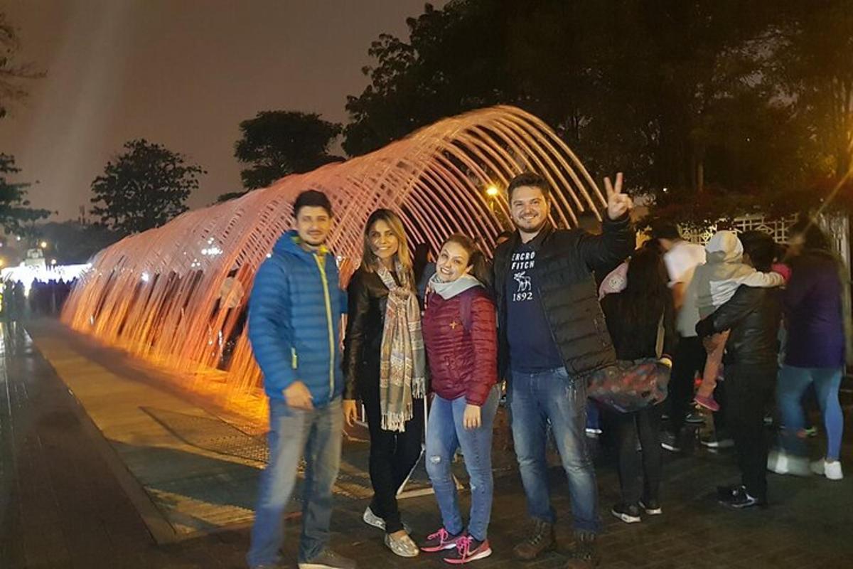 Un grupo de personas de pie frente a una fuente.