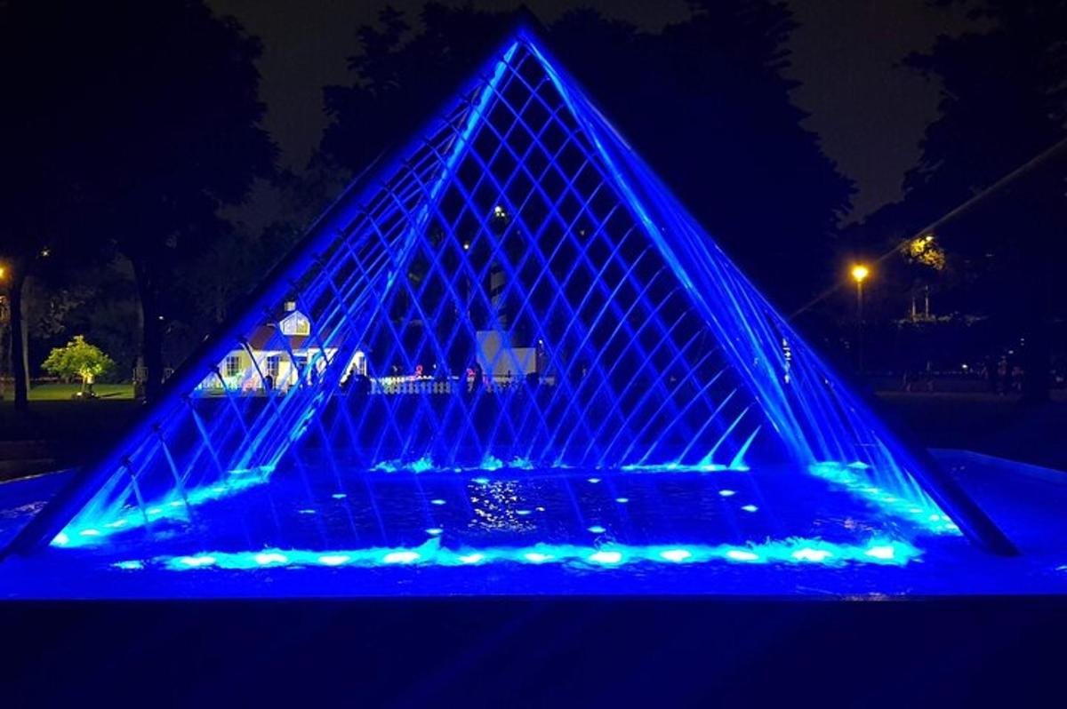 una pirámide iluminada en azul por la noche