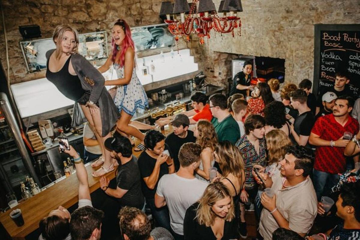 una folla di persone in un bar con due donne in una stanza