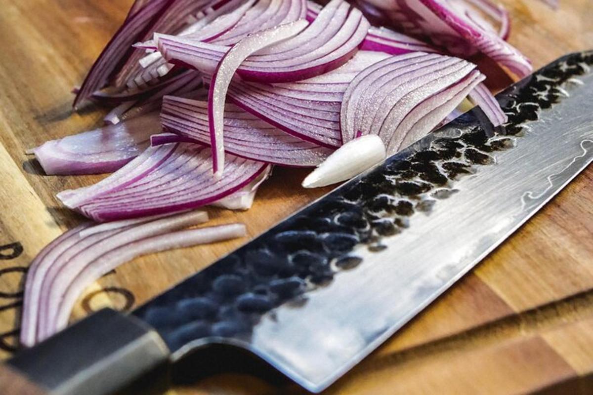 a knife and some onions on a cutting board