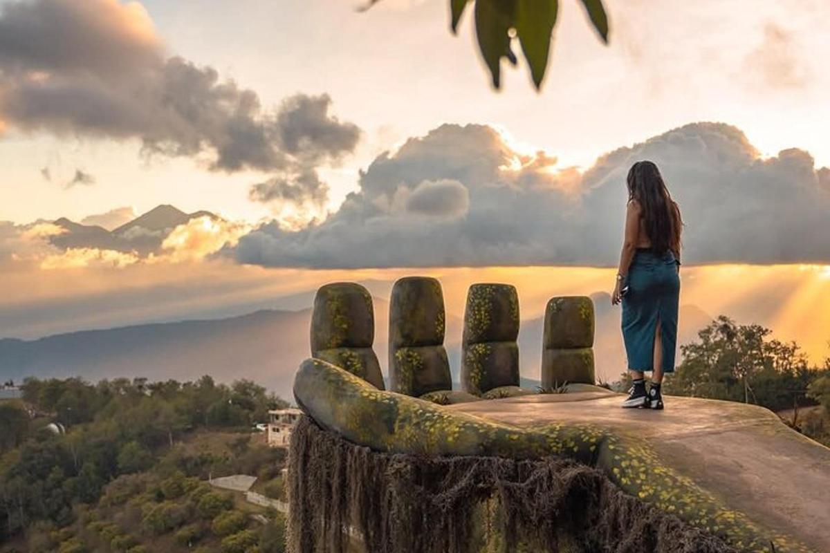a woman standing on top of a hill looking at the sunset