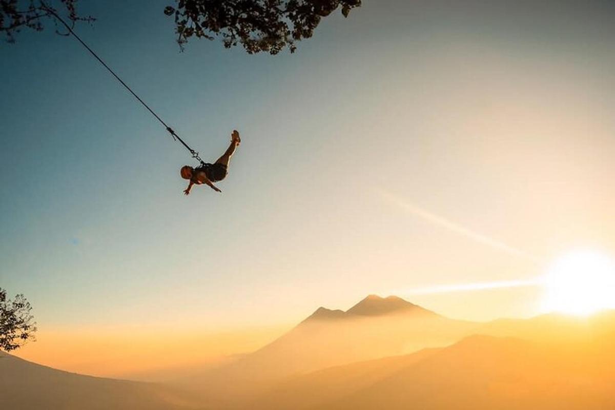 a man on a rope swing over a mountain