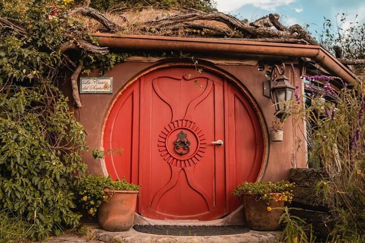 a red door in a small house with plants