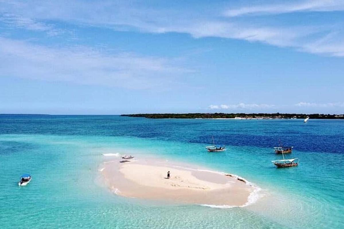 an island in the ocean with boats in the water