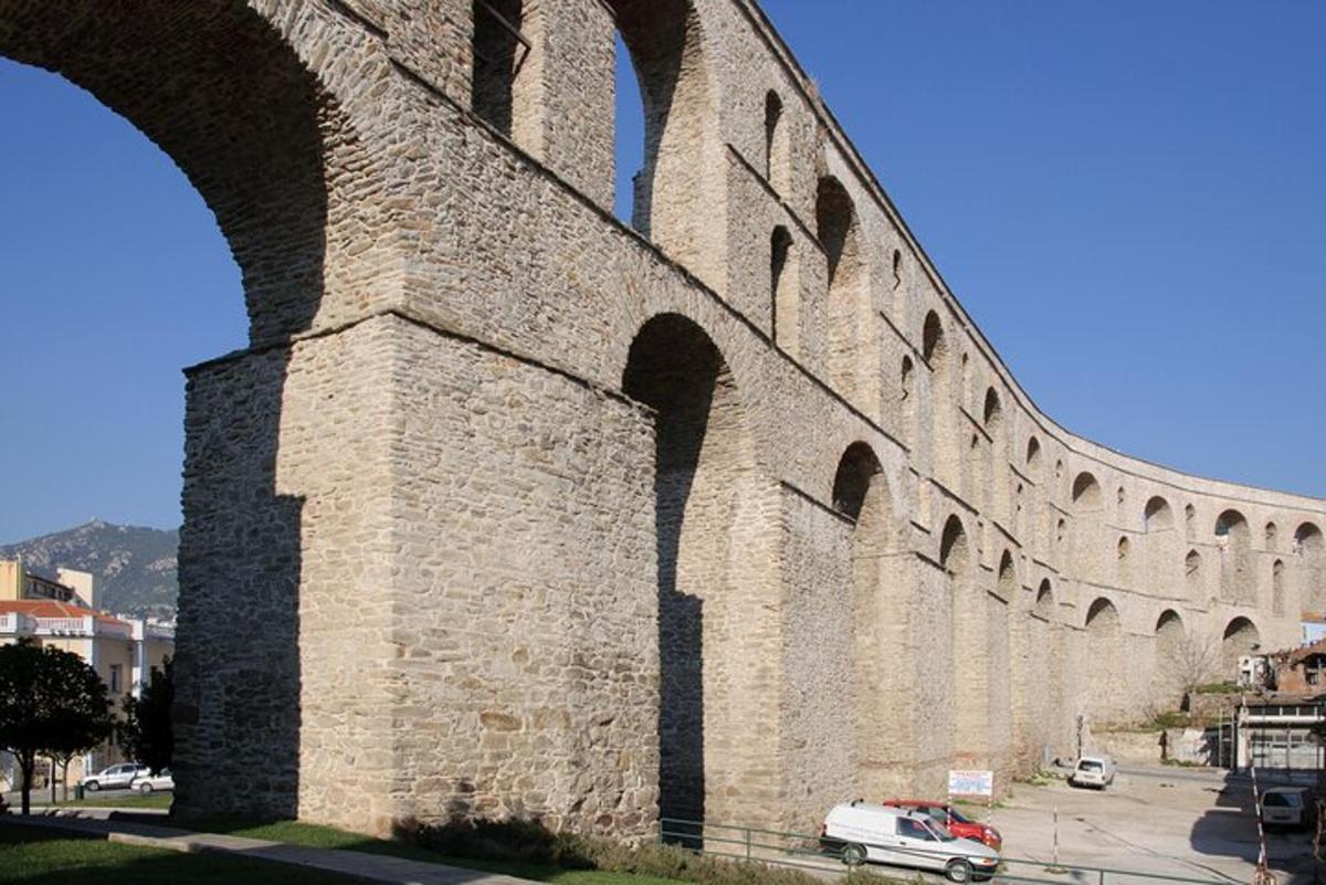 μια μεγάλη πέτρινη γέφυρα με ένα αυτοκίνητο παρκαρισμένο δίπλα της