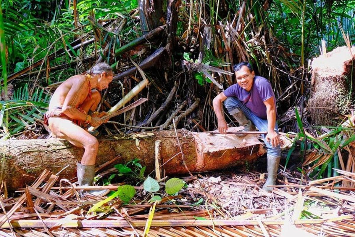 two men are sitting on a tree stump