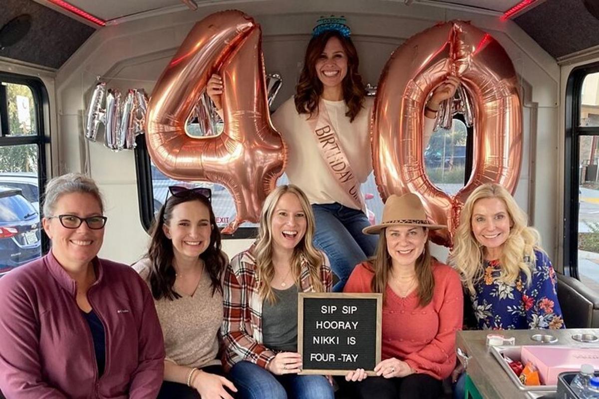 eine Gruppe von Frauen sitzt mit Luftballons in einem Bus
