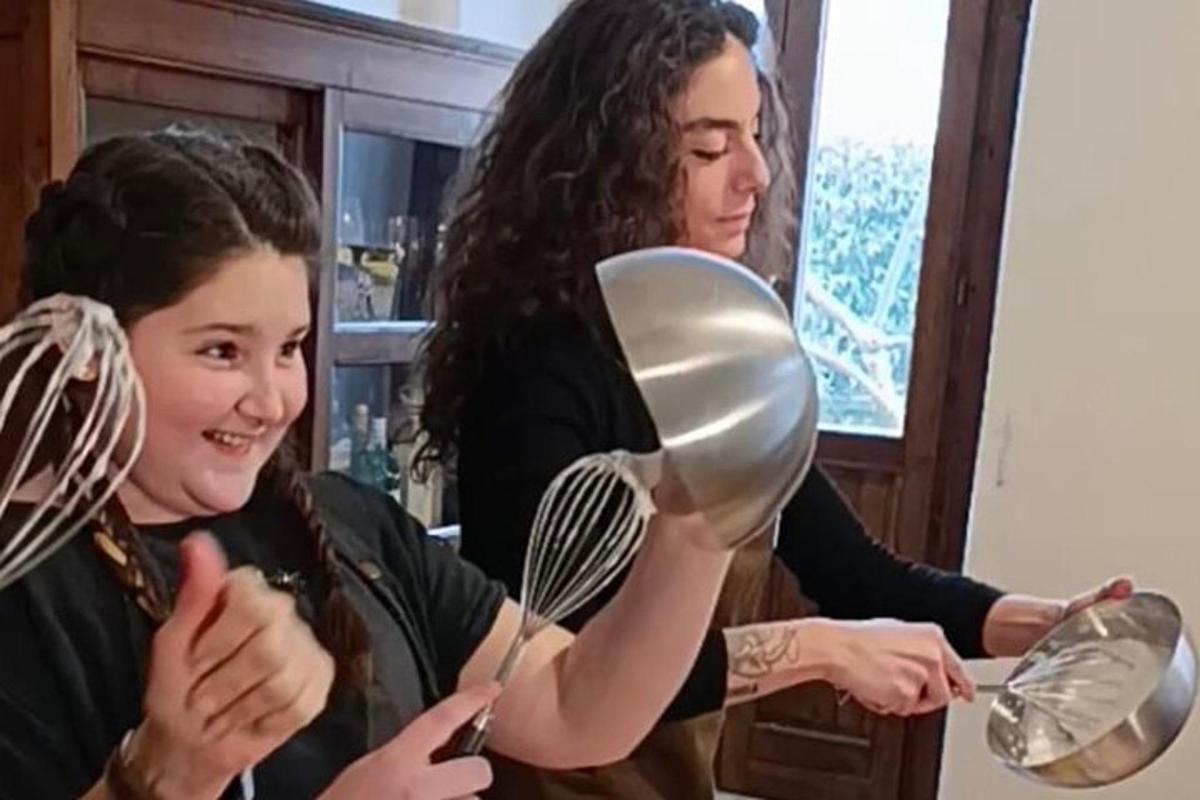 Una mujer ayudando a una niña a cepillarse el cabello.