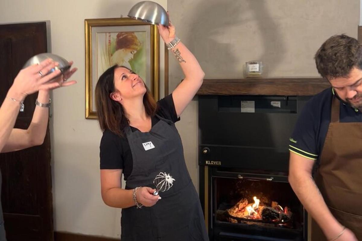 Una mujer sosteniendo una olla frente a una chimenea.