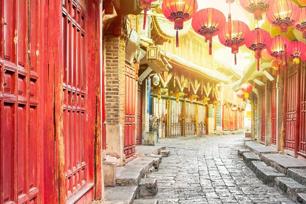 an old street with red buildings and chinese lamps