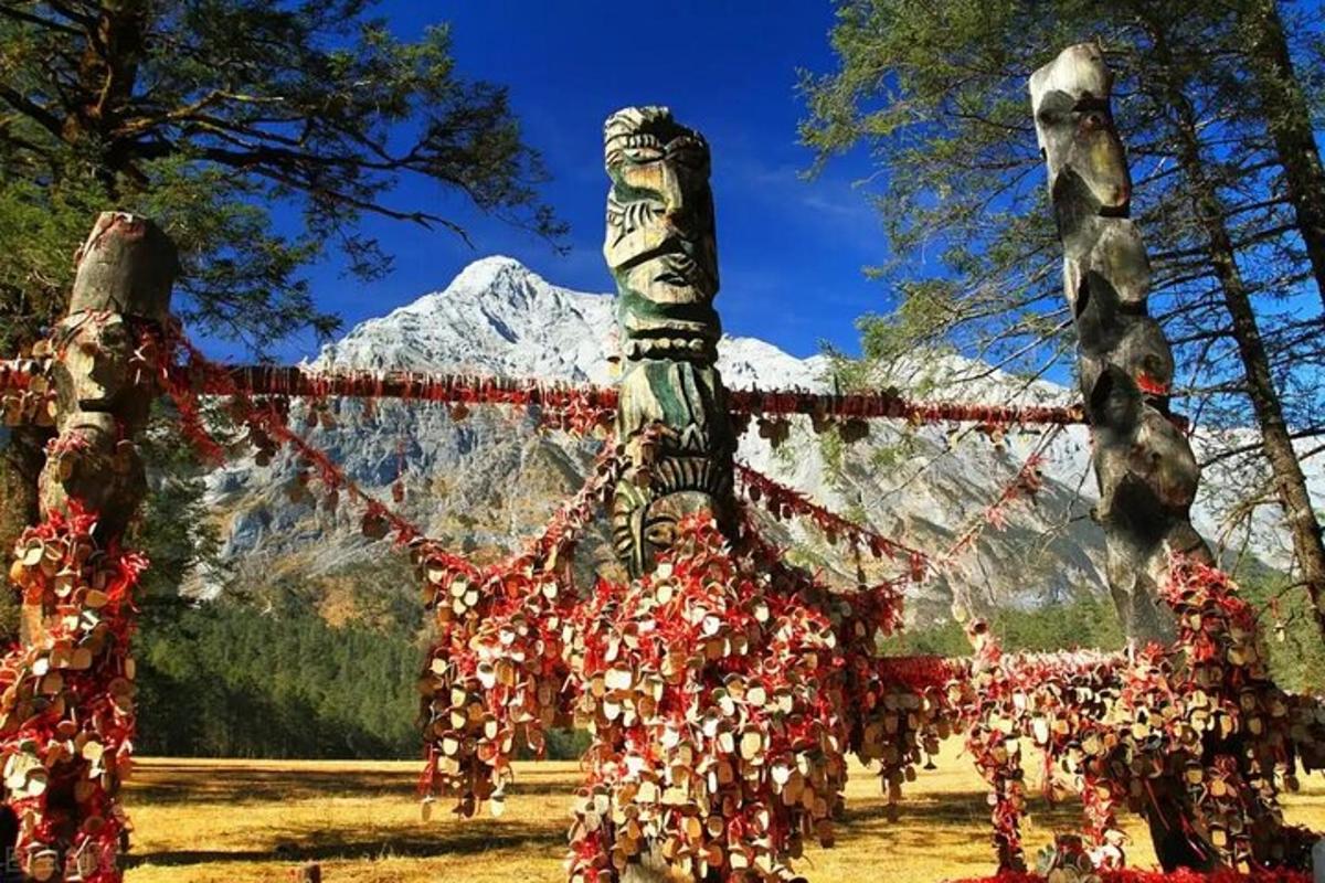 a totem pole with a mountain in the background