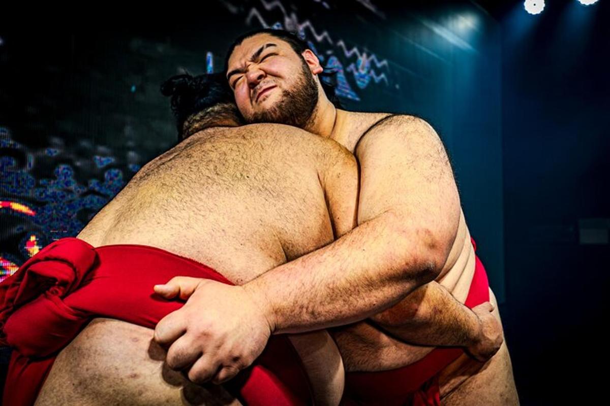 ein Mann umarmt bei einem Wrestling-Kampf den Rücken eines anderen Mannes