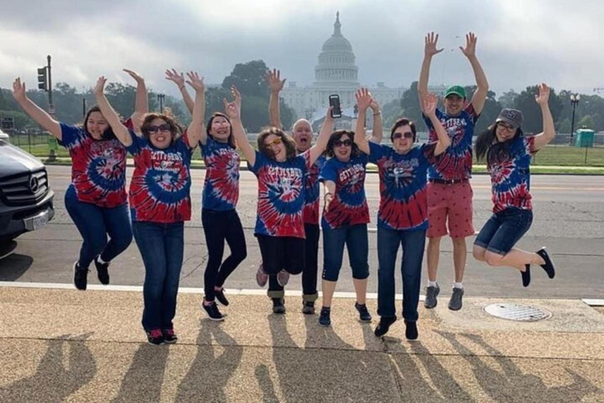 a group of girls jumping in front of the capitol building