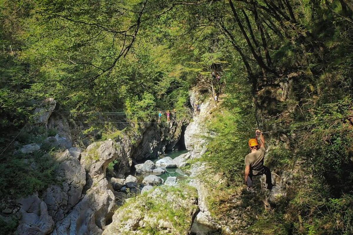 un uomo in piedi sul fianco di una montagna vicino a un fiume