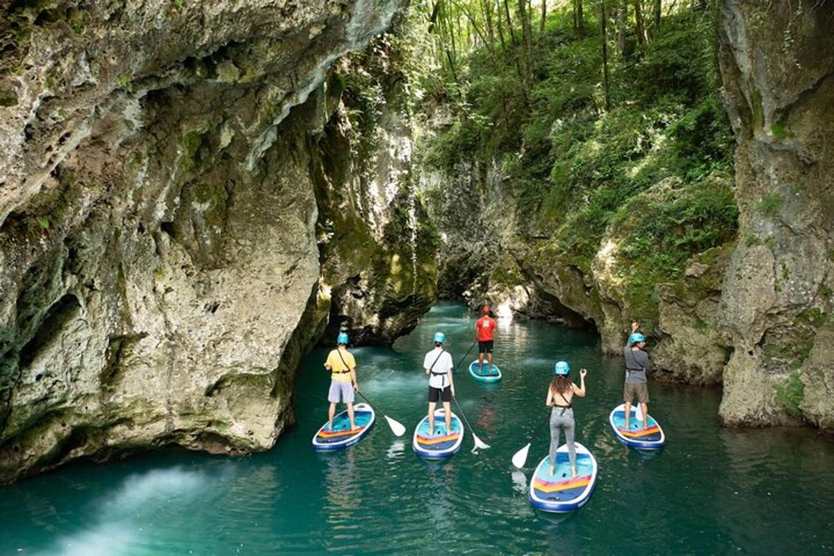 un gruppo di persone su tavole da paddle in una grotta