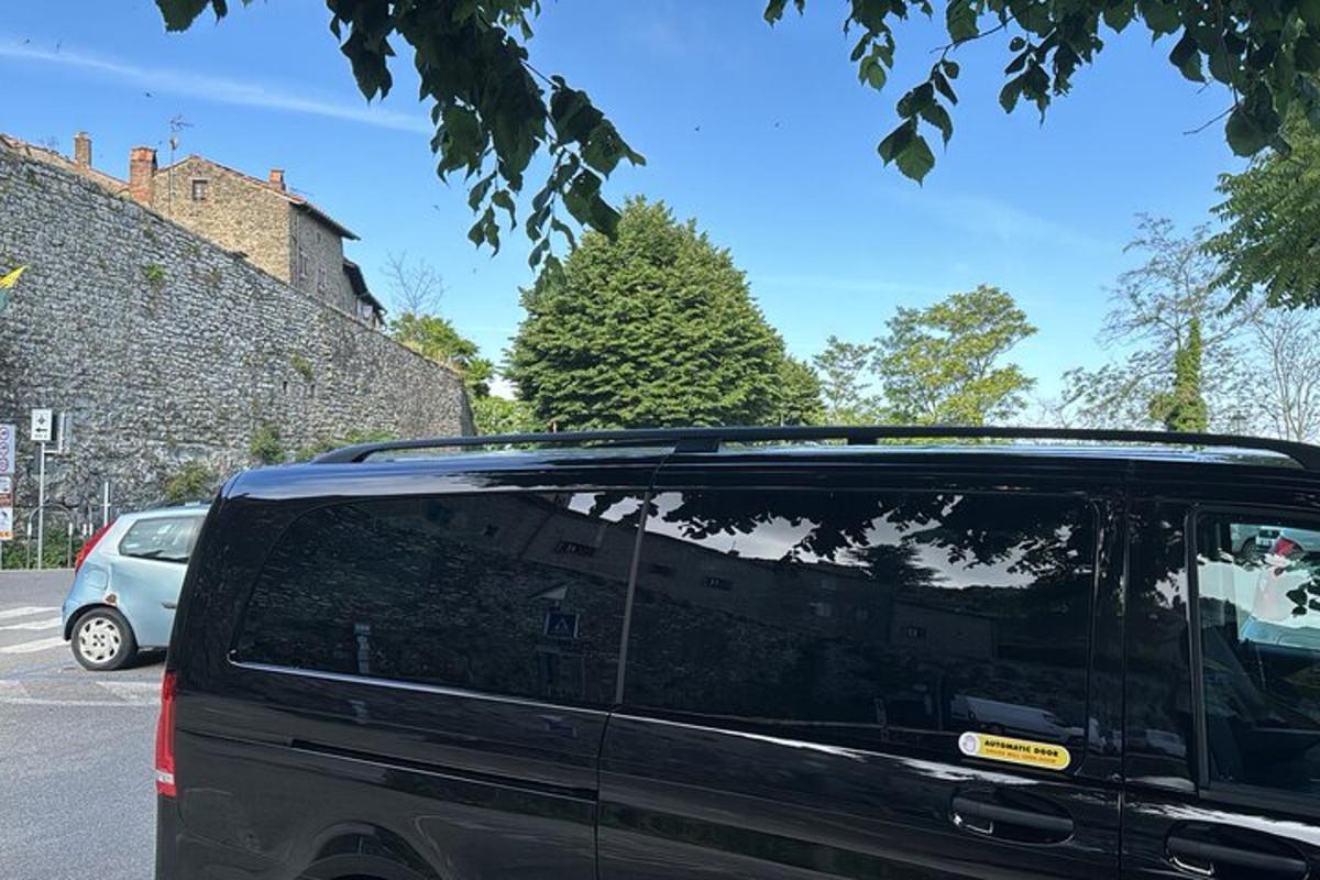 Una camioneta negra estacionada en un estacionamiento al lado de un edificio.