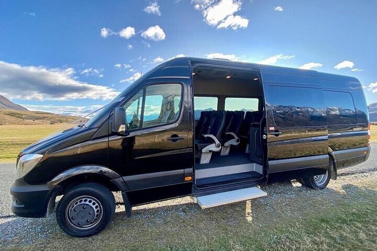 sebuah mobil van hitam diparkir di lapangan dengan pintu terbuka