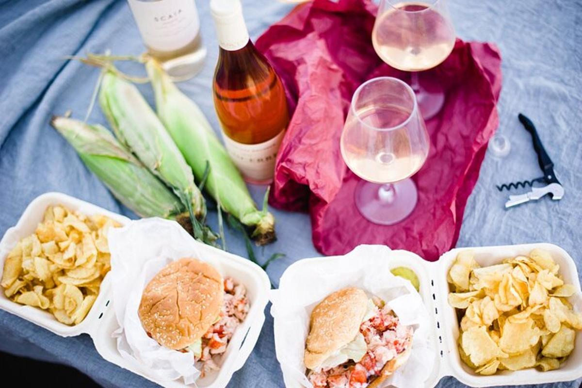 a table with three containers of food and some wine