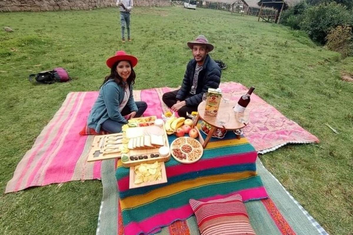 een man en een vrouw zitten op een picknickkleed met eten