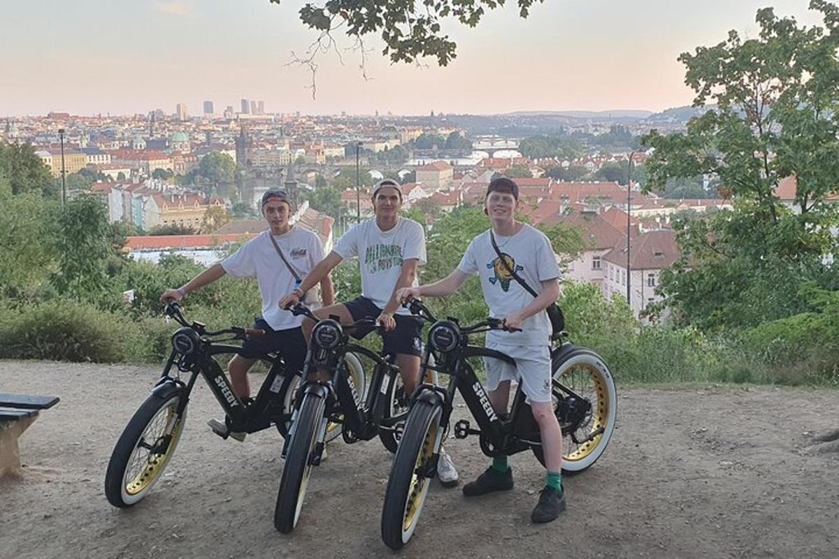 tři muži sedící na kolech před městem