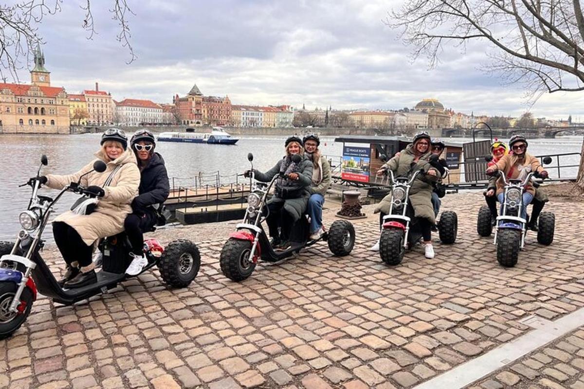 Un grupo de personas viajando en scooters junto al agua.