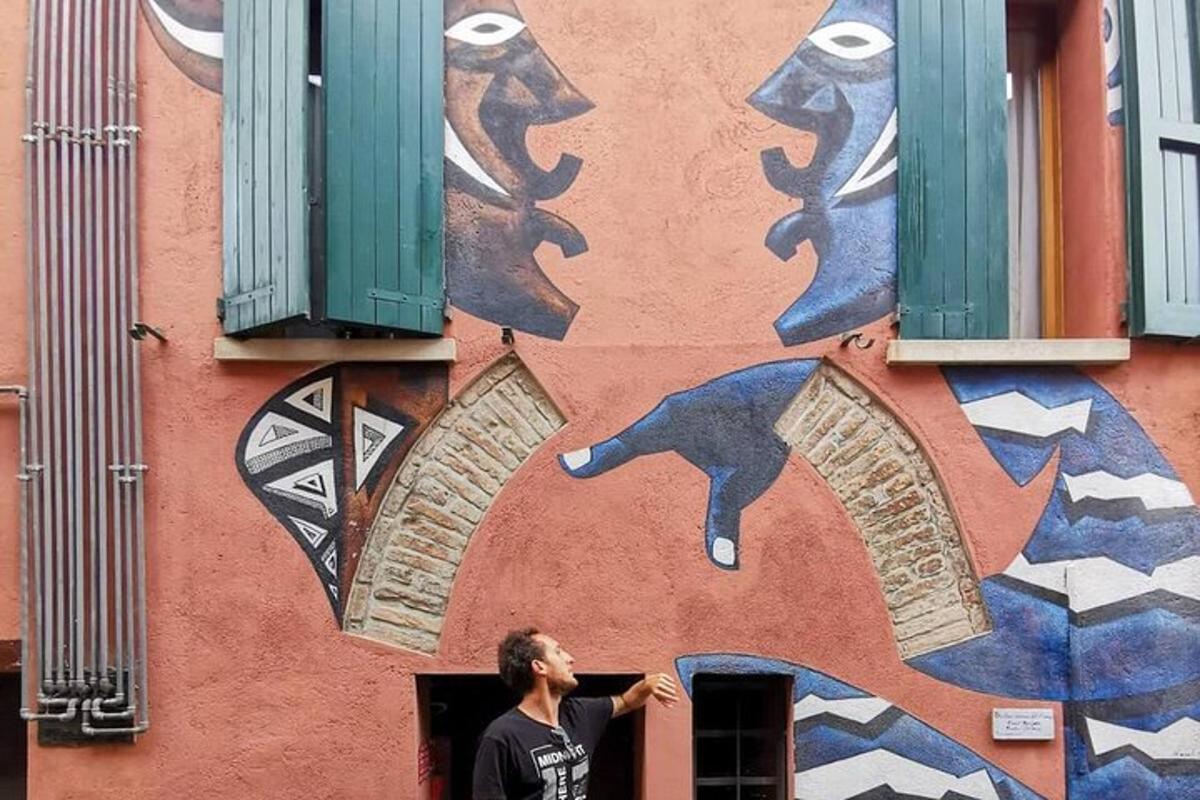 mees seisab grafitiga kaetud hoone ees