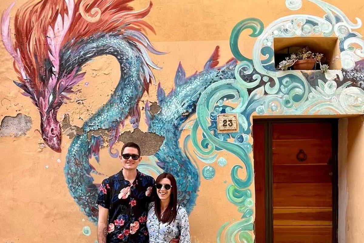 um homem e uma mulher em pé em frente a uma parede com um dragão