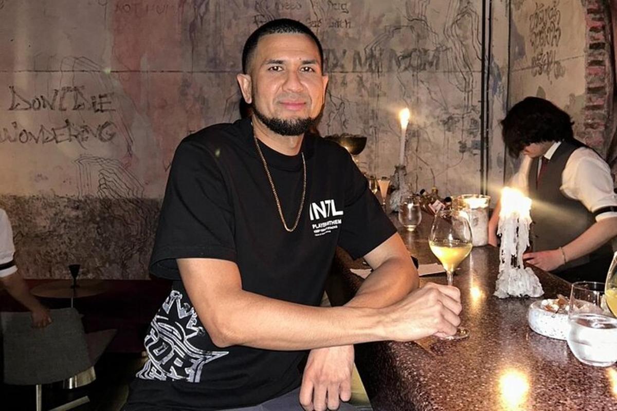 a man sitting at a table with a glass of wine