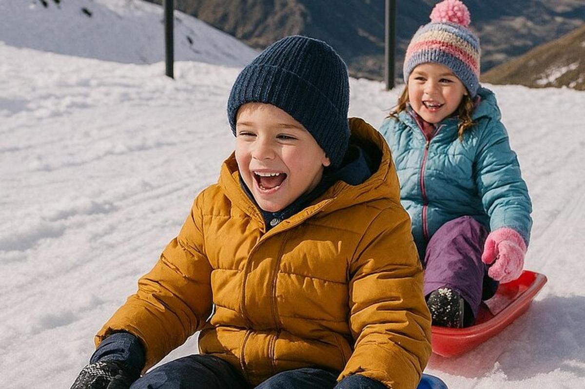 due bambini seduti sulla neve su uno snowboard
