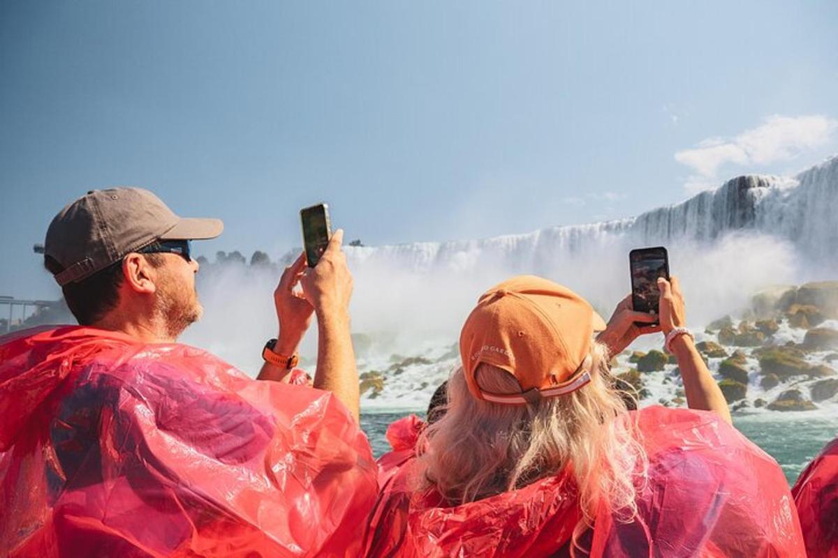 a group of people taking pictures of a waterfall with their cell phones