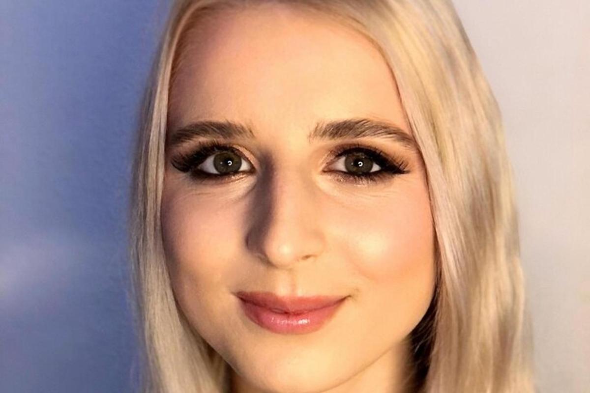 žena s blond vlasy pózující pro fotografii
