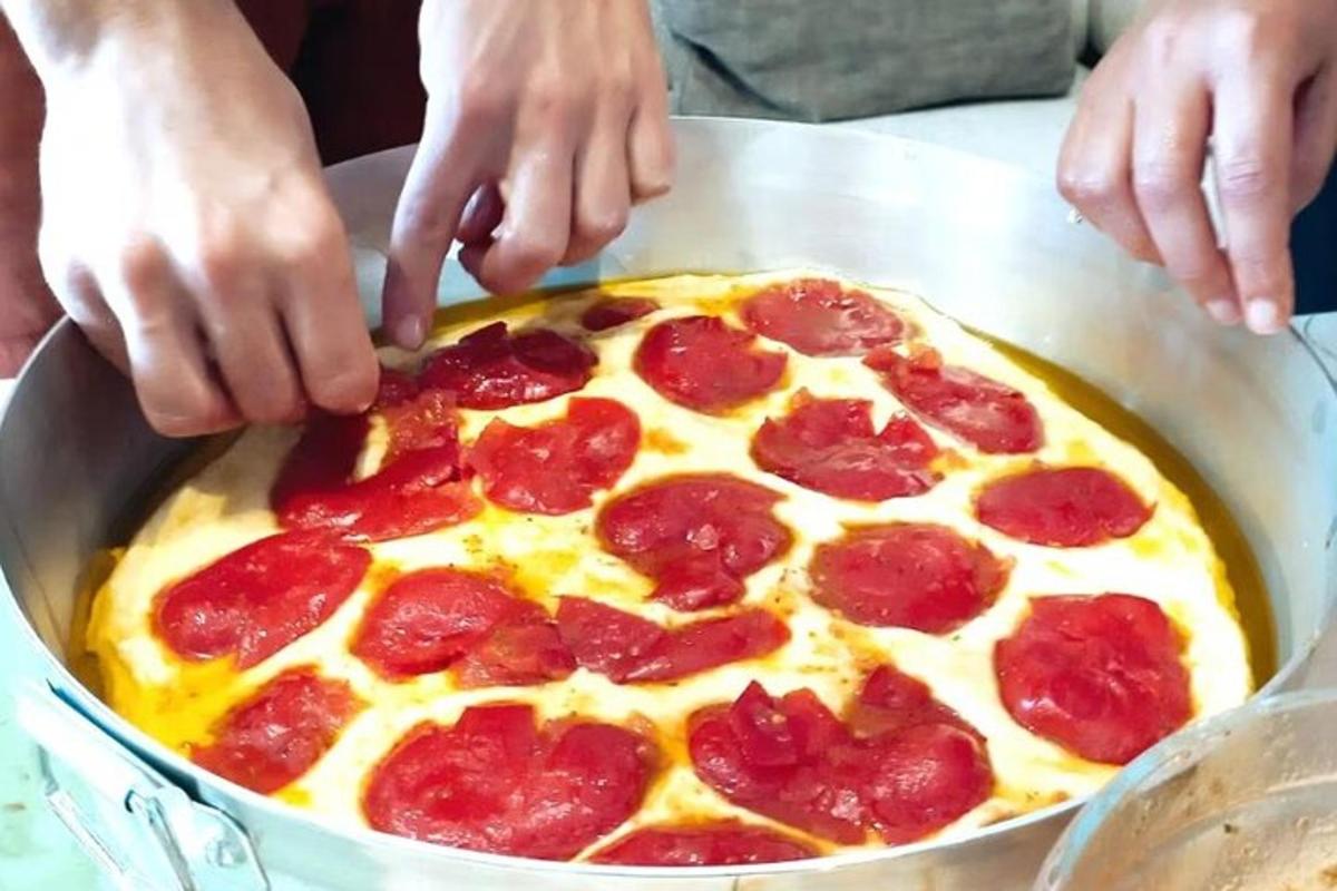 Maður er að búa til pepperoni-pizzu á pönnu